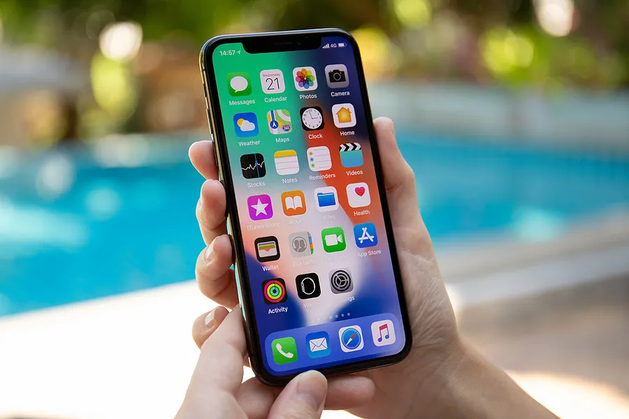 Hand holding iPhone outdoors to show what is True Tone on iPhone.
