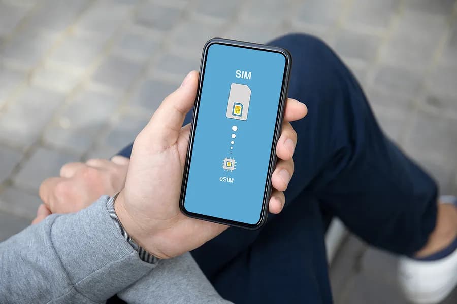 Person sitting with legs crossed holding a mobile phone