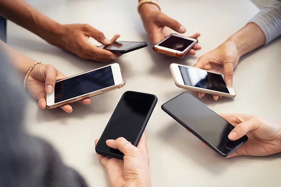 Hands holding mobile devices.