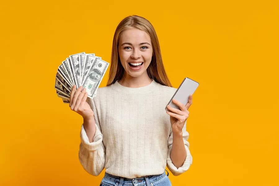 Woman holding a phone and money.