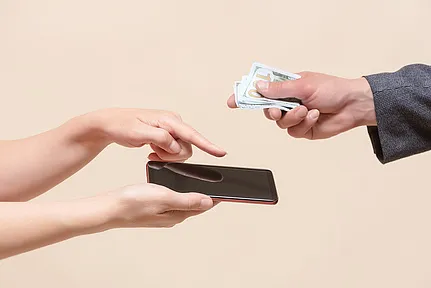 Exchanging mobile phone for money.