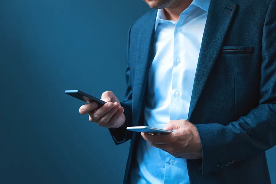Man holding two phones.