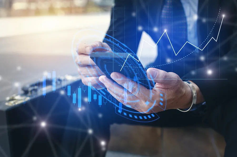 Businessman using smartphone with digital financial graphs overlay