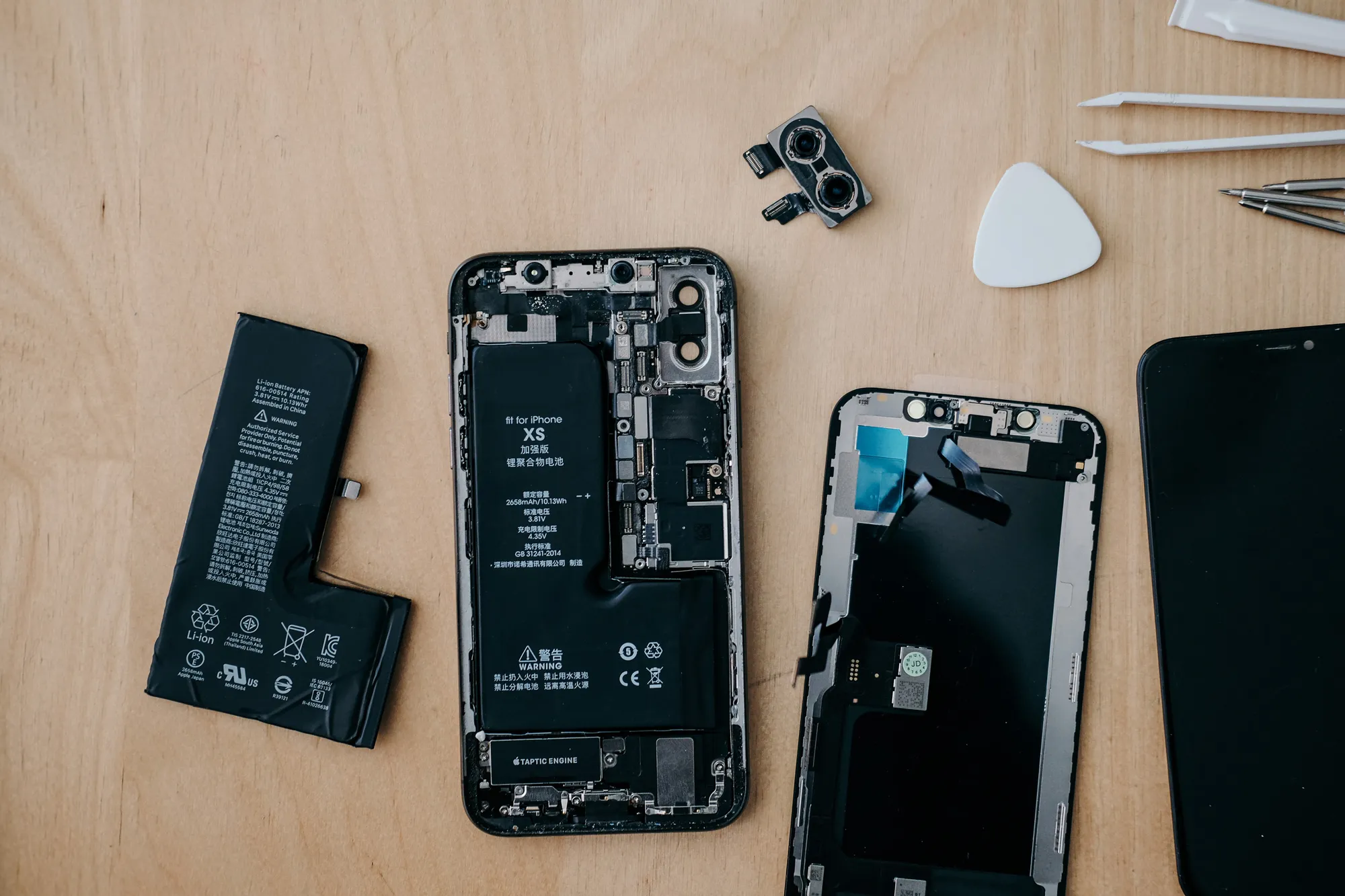 Zerlegtes Smartphone mit internen Komponenten, die auf einer Werkbank ausgelegt sind